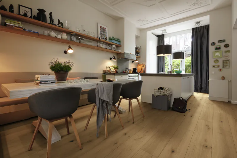 Hochwertiger Parkettboden in einer modernen, offenen Wohnküche mit Essbereich und gemütlicher Sitzbank.