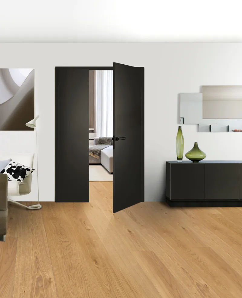 Moderne, schwarze CPL-Innentür von Grauthoff in einem elegant eingerichteten Wohnraum mit hellem Holzboden.