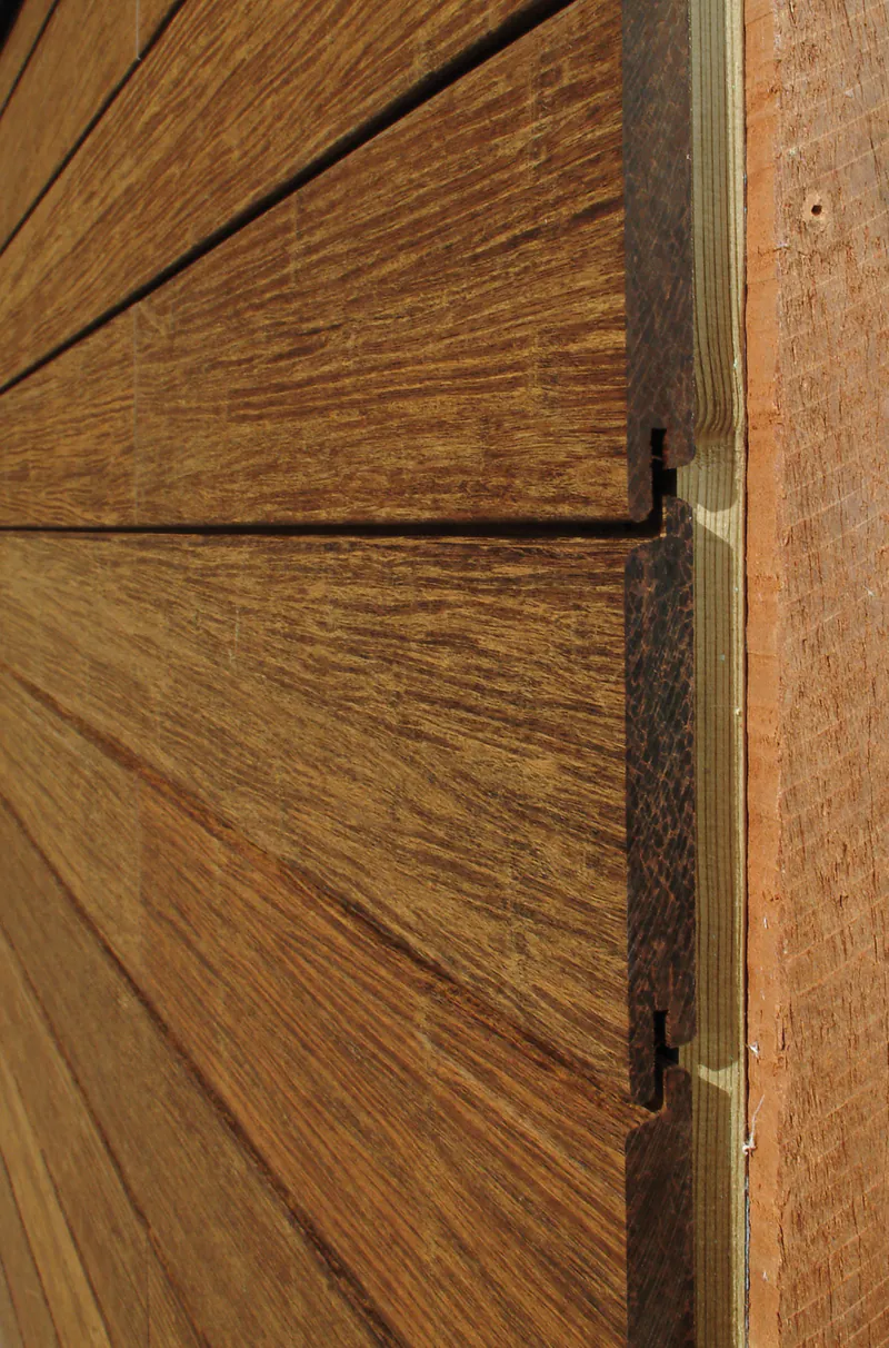 Detailaufnahme einer hochwertigen Bambus-Fassadenverkleidung mit sichtbarer Nut- und Feder-Verbindung für eine moderne Holzoptik.