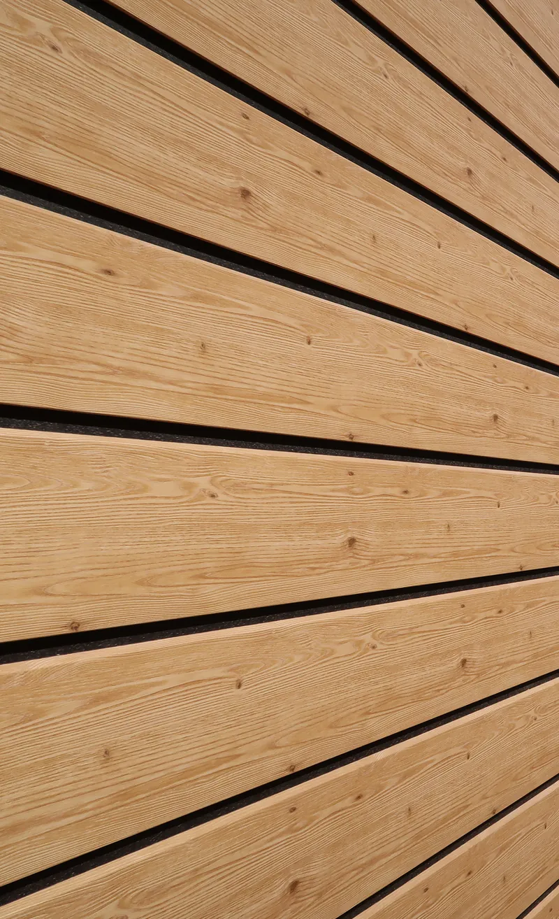 Nahaufnahme einer Dekodeck Holz-Fassadenverkleidung von Disselnmeyer mit natürlicher Maserung und horizontalen Fugen.