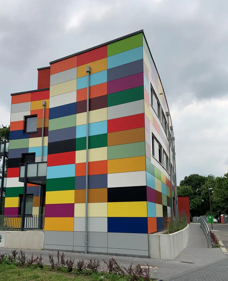 Fassade eines modernen Gebäudes mit farbenfrohen Trespa Meteon Uni-Color Fassadenplatten von Disselnmeyer.
