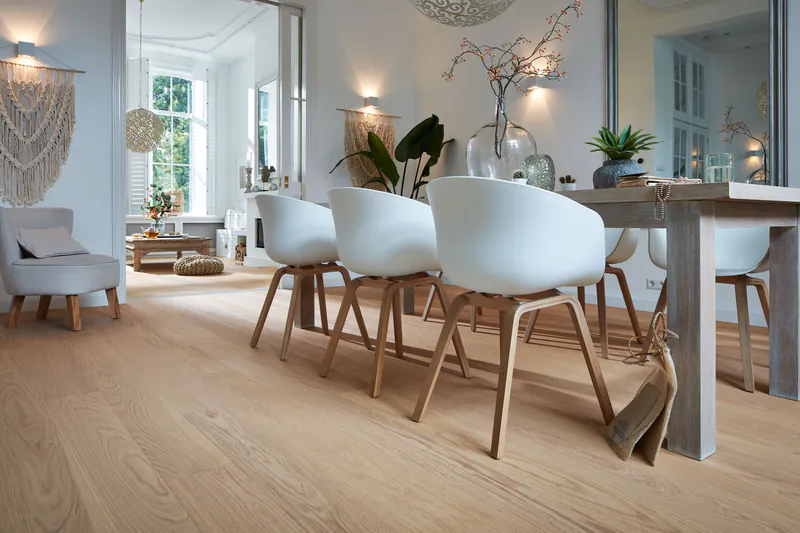 Heller Parkettboden in einem modern eingerichteten Esszimmer mit weißem Mobiliar und gemütlicher Wohnatmosphäre.