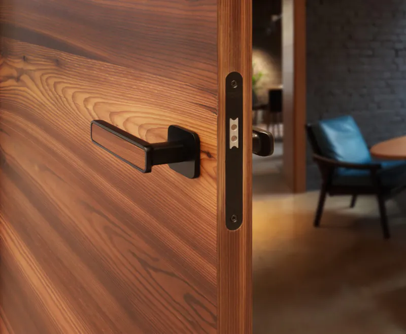 Detailaufnahme einer hochwertigen HGM-Innentür aus Echtholz Lärche mit markanter Quer-Maserung und modernem schwarzen Türdrücker.