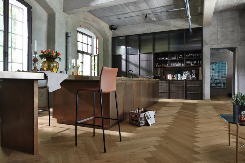 Moderne Küche im Industrie-Loft-Stil mit ultramatt lackiertem Holzboden im Fischgrätmuster und einer großen Kücheninsel.