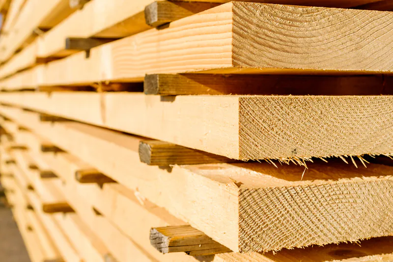 bohlen-2614ea32 Gestapelte, sägeraue Holzbalken und Bretter für Bauprojekte im Sägewerk.