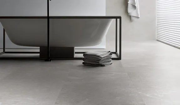 Moderner, grauer Ter Hürne Soya Vinylboden in einem eleganten Badezimmer mit Badewanne.