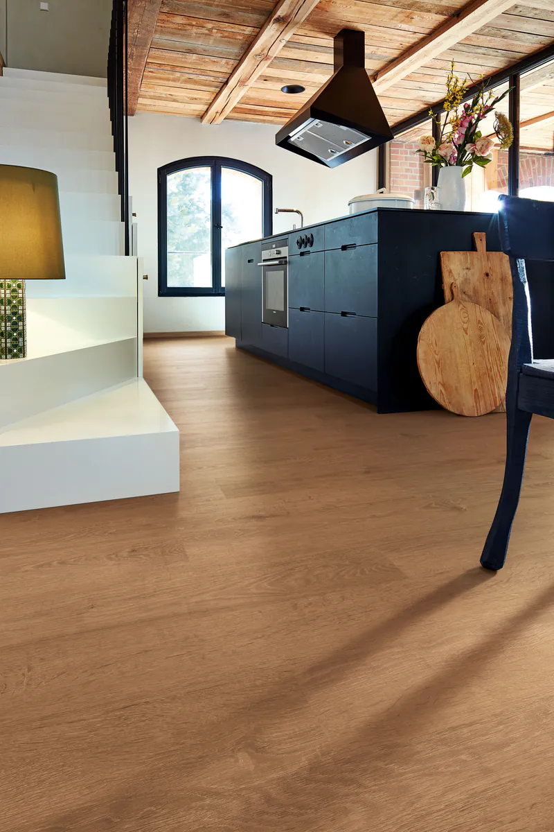 laminat-9b557ca0 Moderner Wohnraum mit hochwertigem Eichen-Laminatboden in einer offenen Küche mit dunkler Küchenzeile und rustikaler Holzdecke.