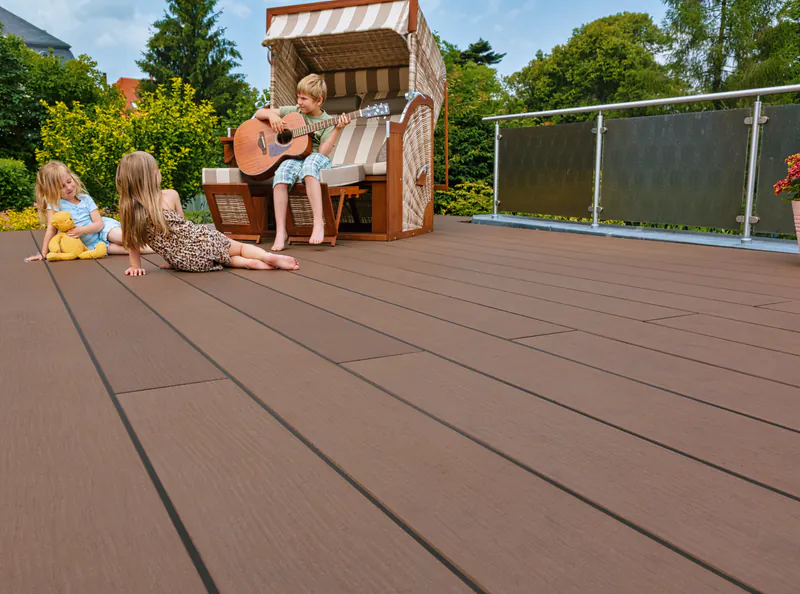 premium-plus-terrassendiele-megawood-holz-disselnmeyer-d3787427 Kinder spielen und musizieren auf einer Premium Plus Terrassendiele von Megawood im heimischen Garten.